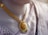 A close-up view of an ornate gold necklace with intricate designs and colorful gemstones, worn by a person dressed in a traditional garment with intricate patterns.