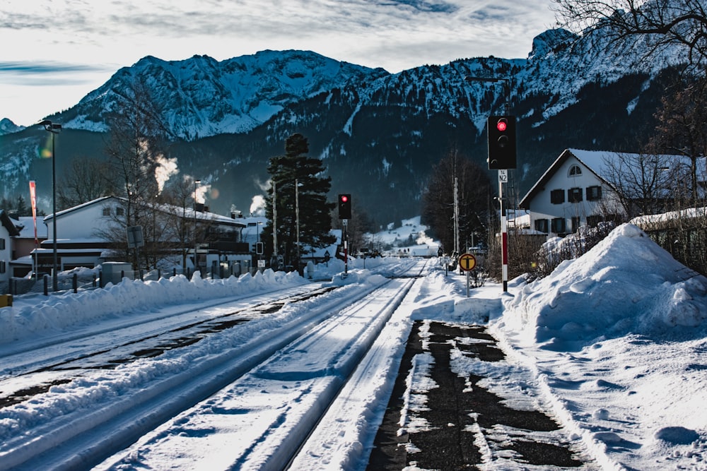 snow covered road near mountain during daytime