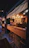 Cozy corner of the bar with rustic wooden tables and softly glowing lanterns.