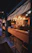 Cozy corner of the bar with rustic wooden tables and softly glowing lanterns.