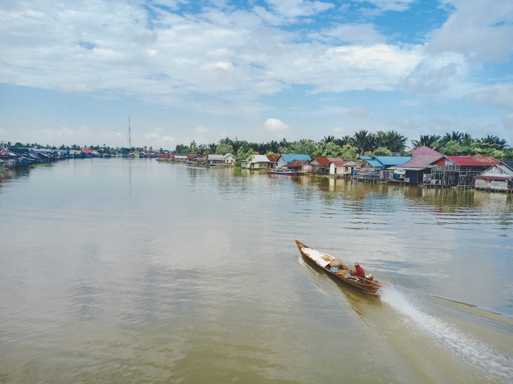 red and white boat on water near houses during daytime