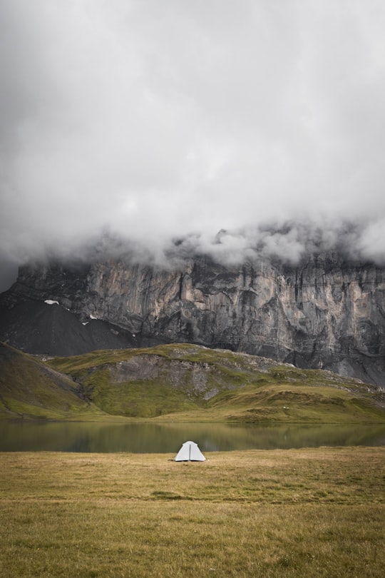 white tent on green grass field near gray rocky mountain during daytime in Haute-Savoie France
