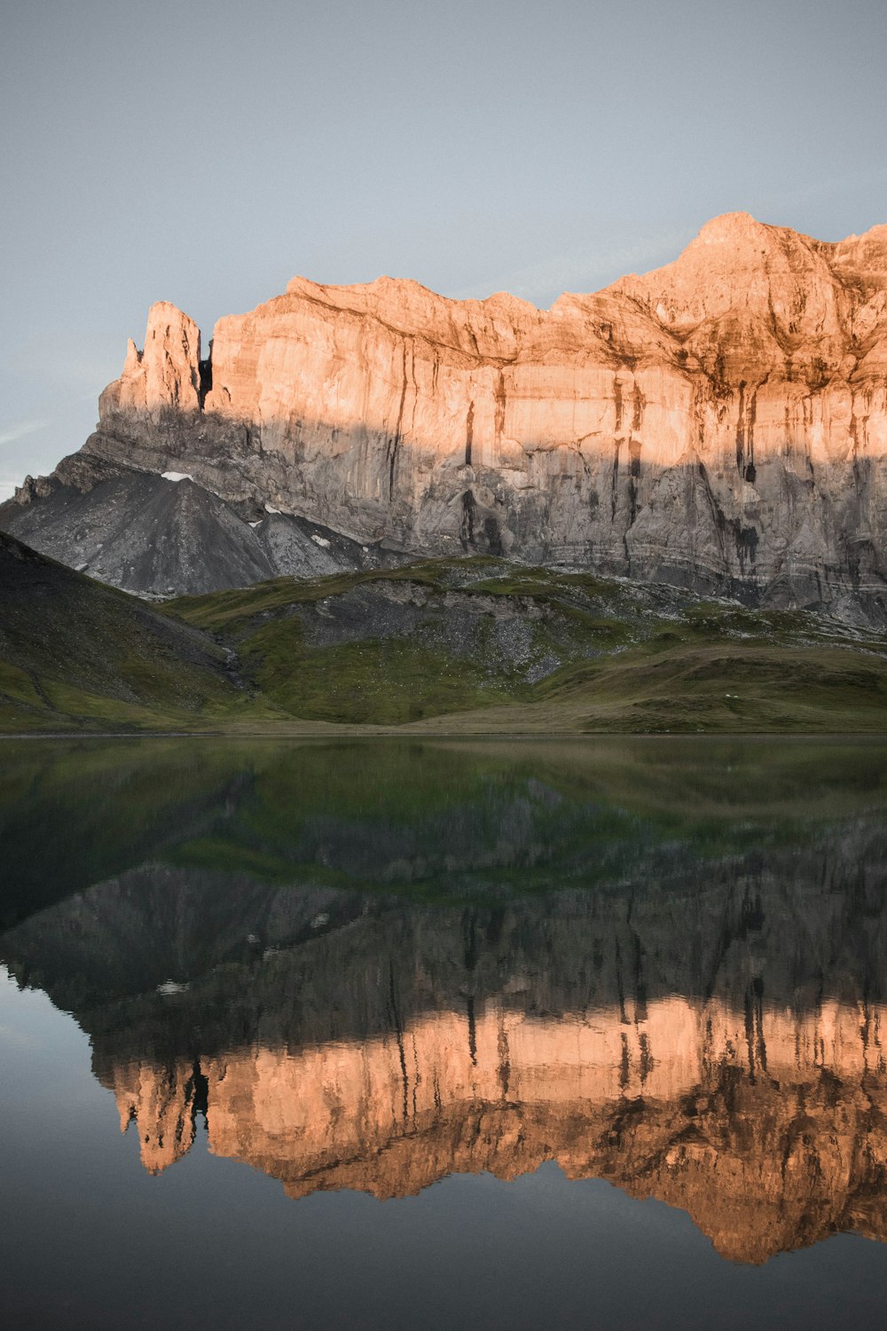 Montaña rocosa marrón junto al lago durante el día