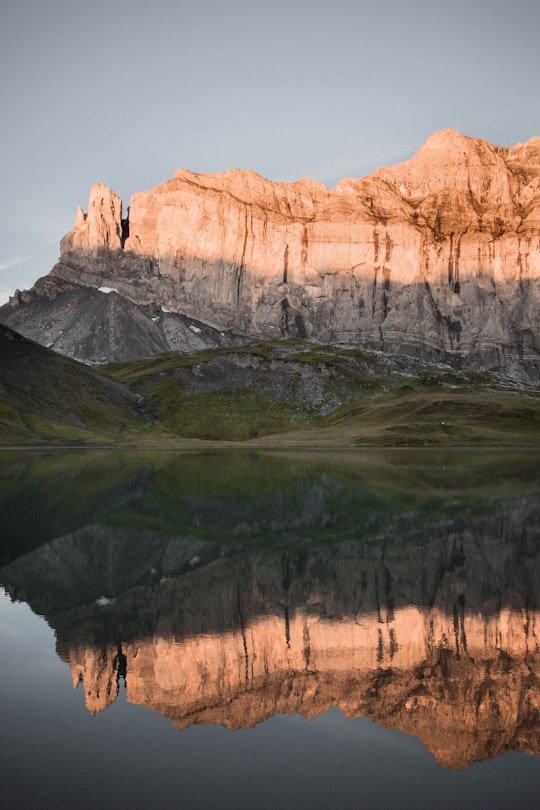 brown rocky mountain beside lake during daytime in Haute-Savoie France