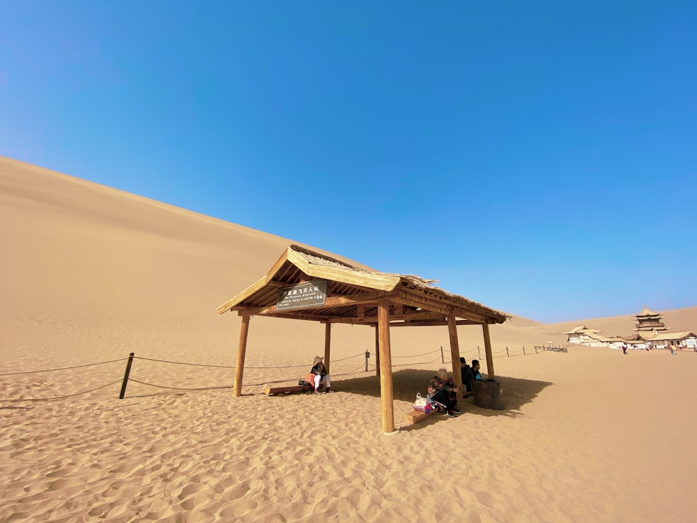 brown wooden beach house on brown sand during daytime