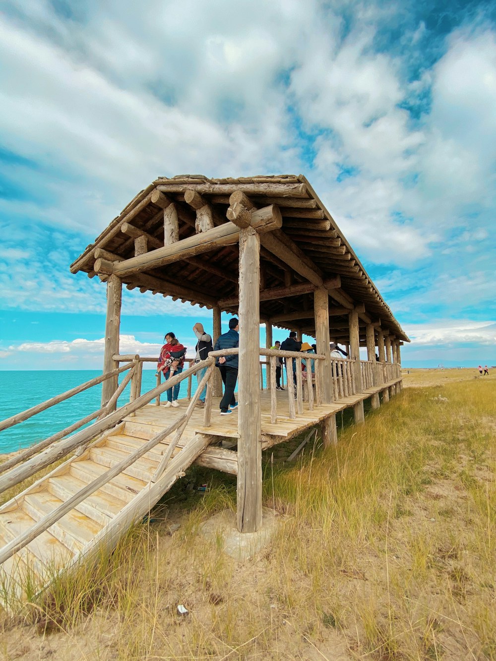 man and woman sitting on wooden dock during daytime