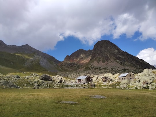 white and brown house near mountain under white clouds during daytime in Refuge de Vallonpierre France
