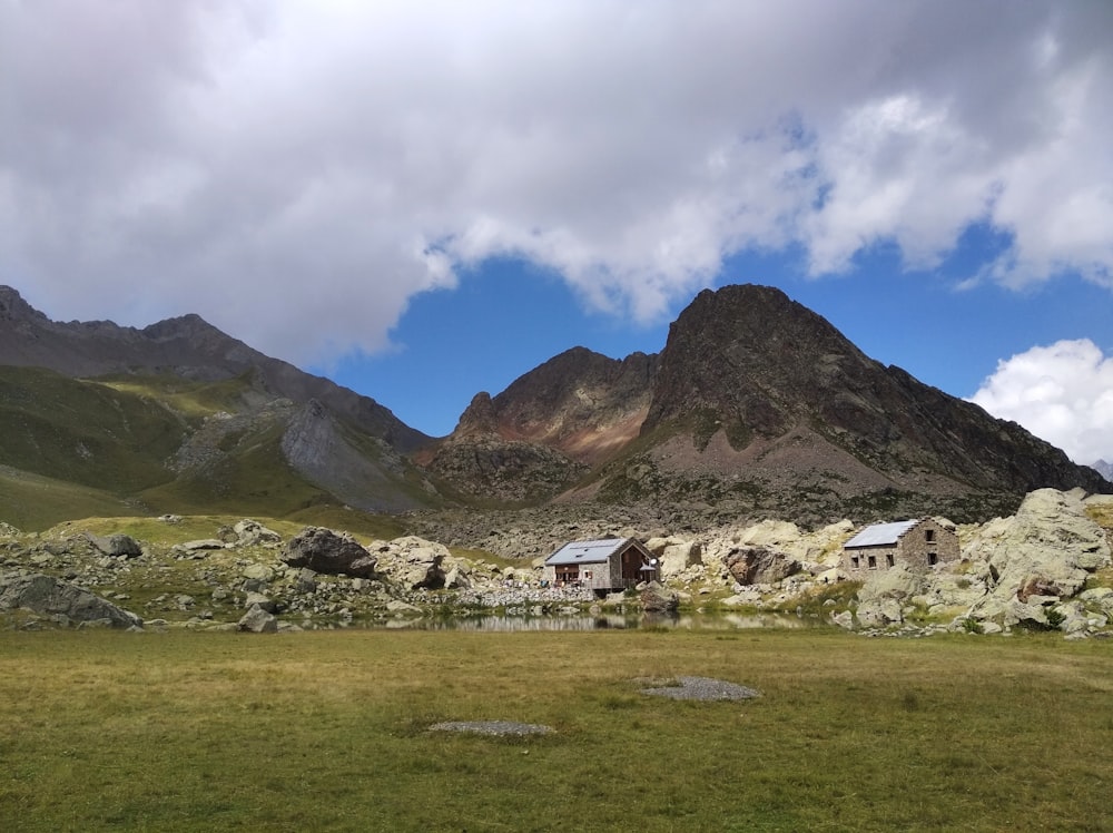 white and brown house near mountain under white clouds during daytime