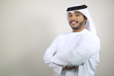 A confident man in business attire speaking on phone with a map of the Gulf region behind.