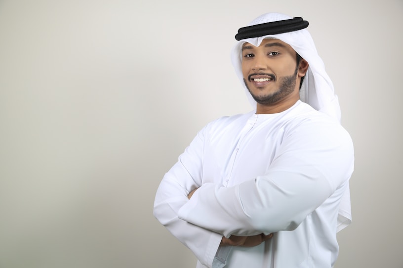 A stylish young man wearing a modern Muslim outfit from Almeera, standing confidently in an urban setting.