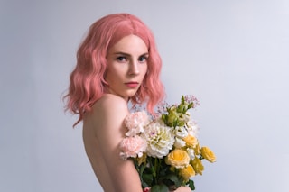 woman holding white and yellow flowers