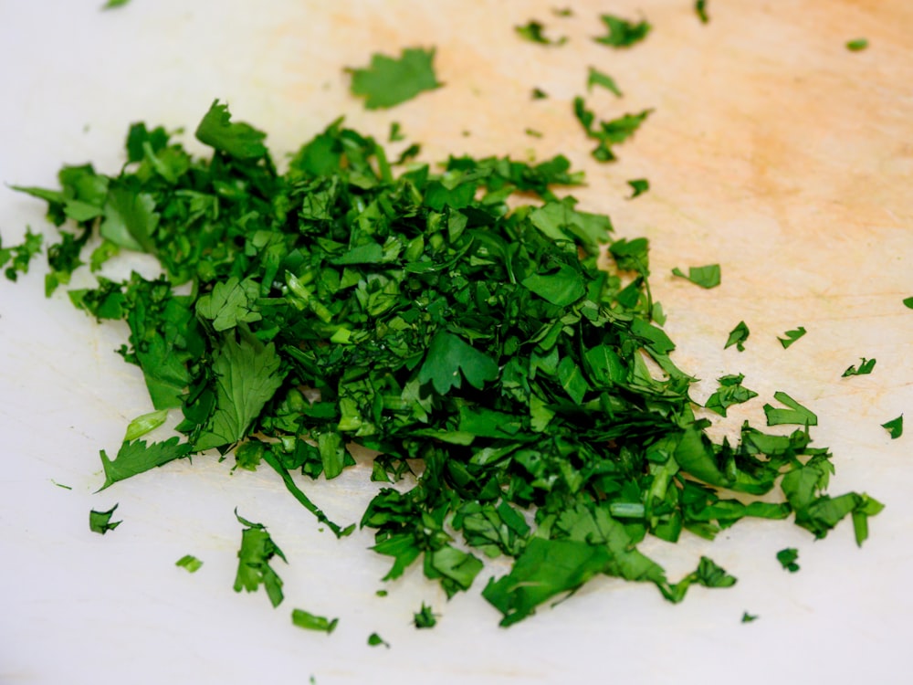 hojas verdes sobre plato de cerámica blanca