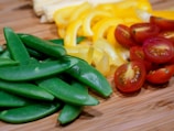 Close-up of fresh ingredients including vegetables and herbs on a cutting board.