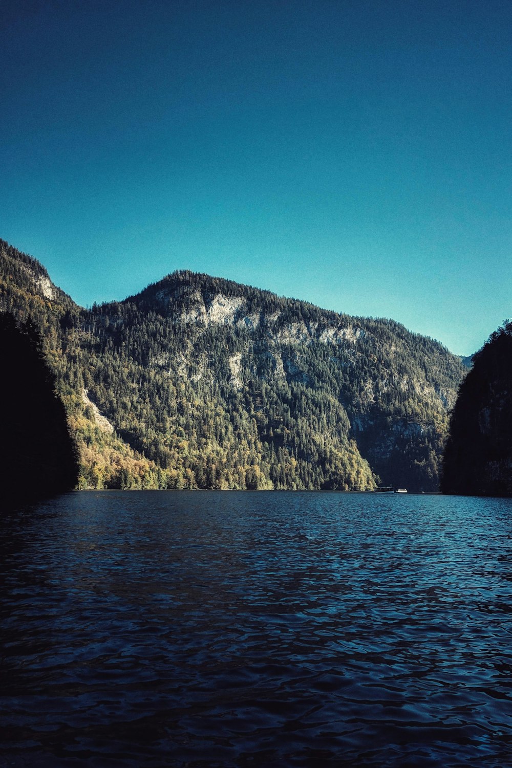 body of water near mountain during daytime