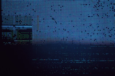 An array of small, evenly spaced blue, white, and black dots form a digital pattern. The pattern resembles a screen or display with abstract outlines and subtle color variations.