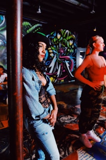 man and woman standing beside wall with graffiti