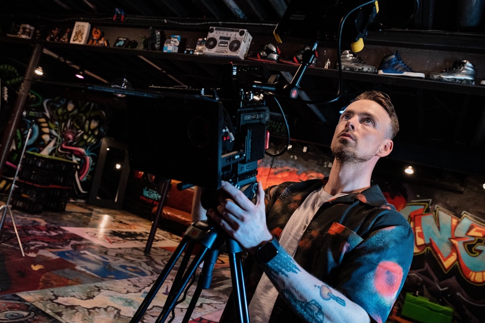 man in black and red shirt holding black camera