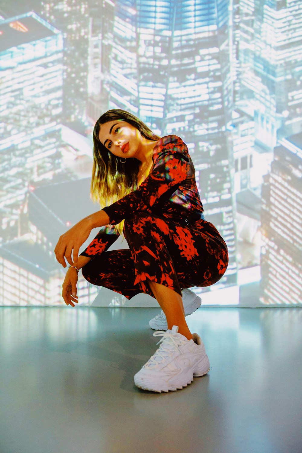 woman in black and red floral dress sitting on white floor