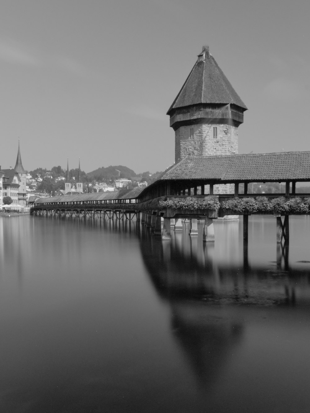 grayscale photo of concrete building near body of water