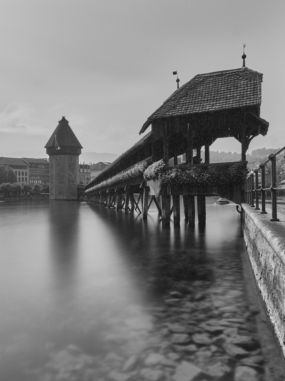grayscale photo of wooden house on water