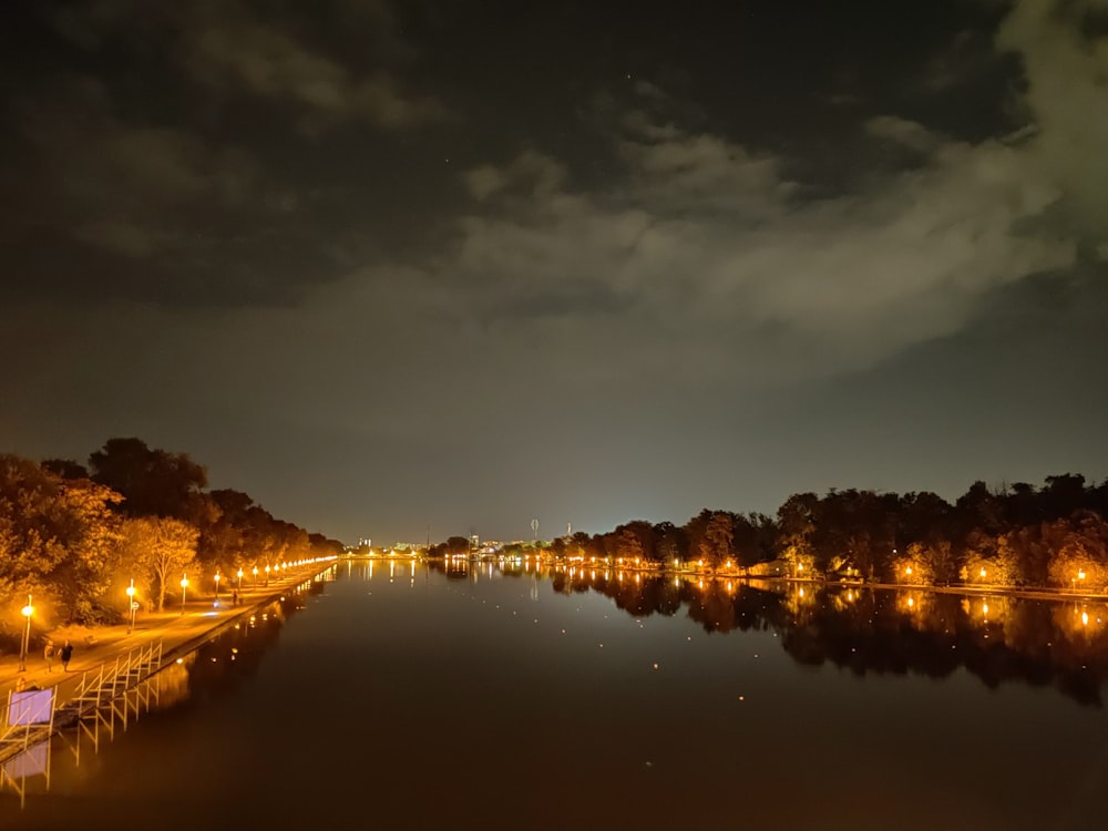 body of water near city buildings during night time