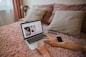 person using macbook pro on bed