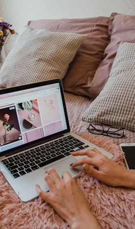 person using macbook pro on bed