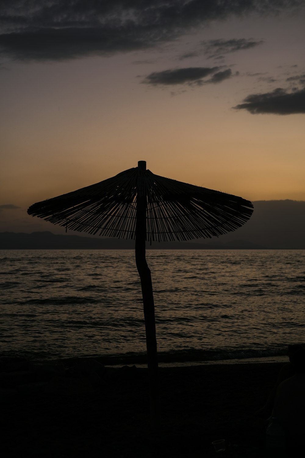 brown wooden beach umbrella on beach during sunset