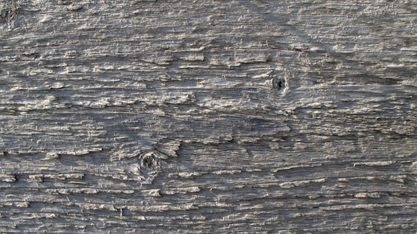 Close-up of weathered wooden exterior panels with visible grain and knots.
