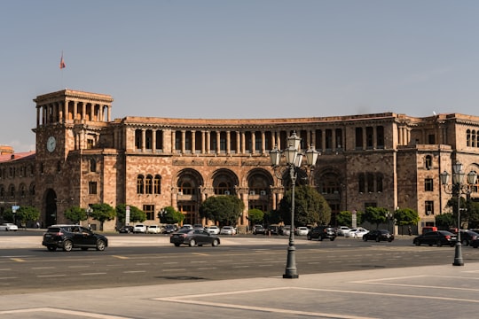 cars parked in front of brown building in Republic Square Armenia