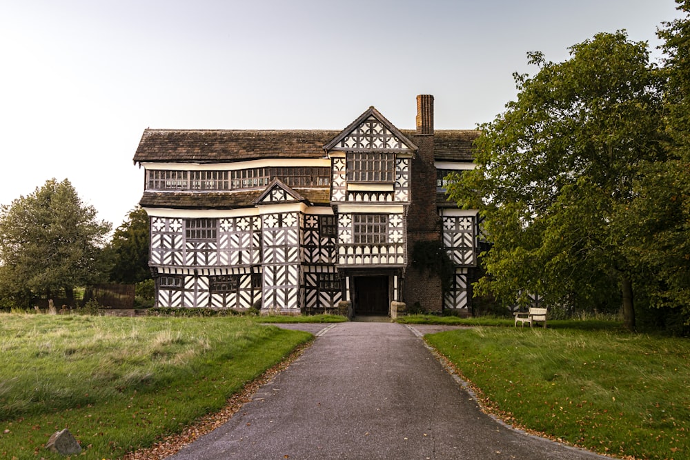 brown and white wooden house near green grass field during daytime