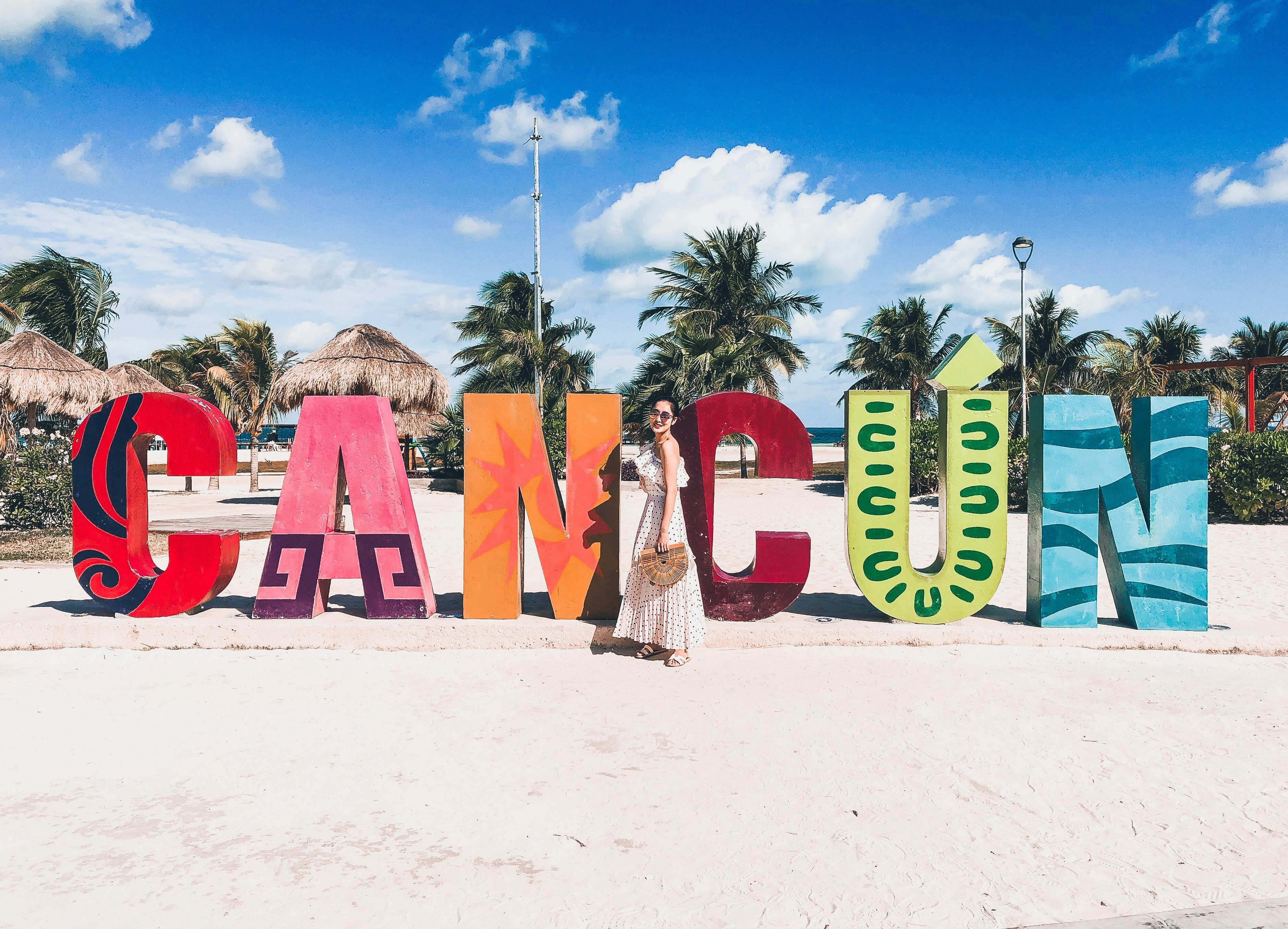 people sitting on red chairs on white sand during daytime