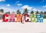 people sitting on red chairs on white sand during daytime
