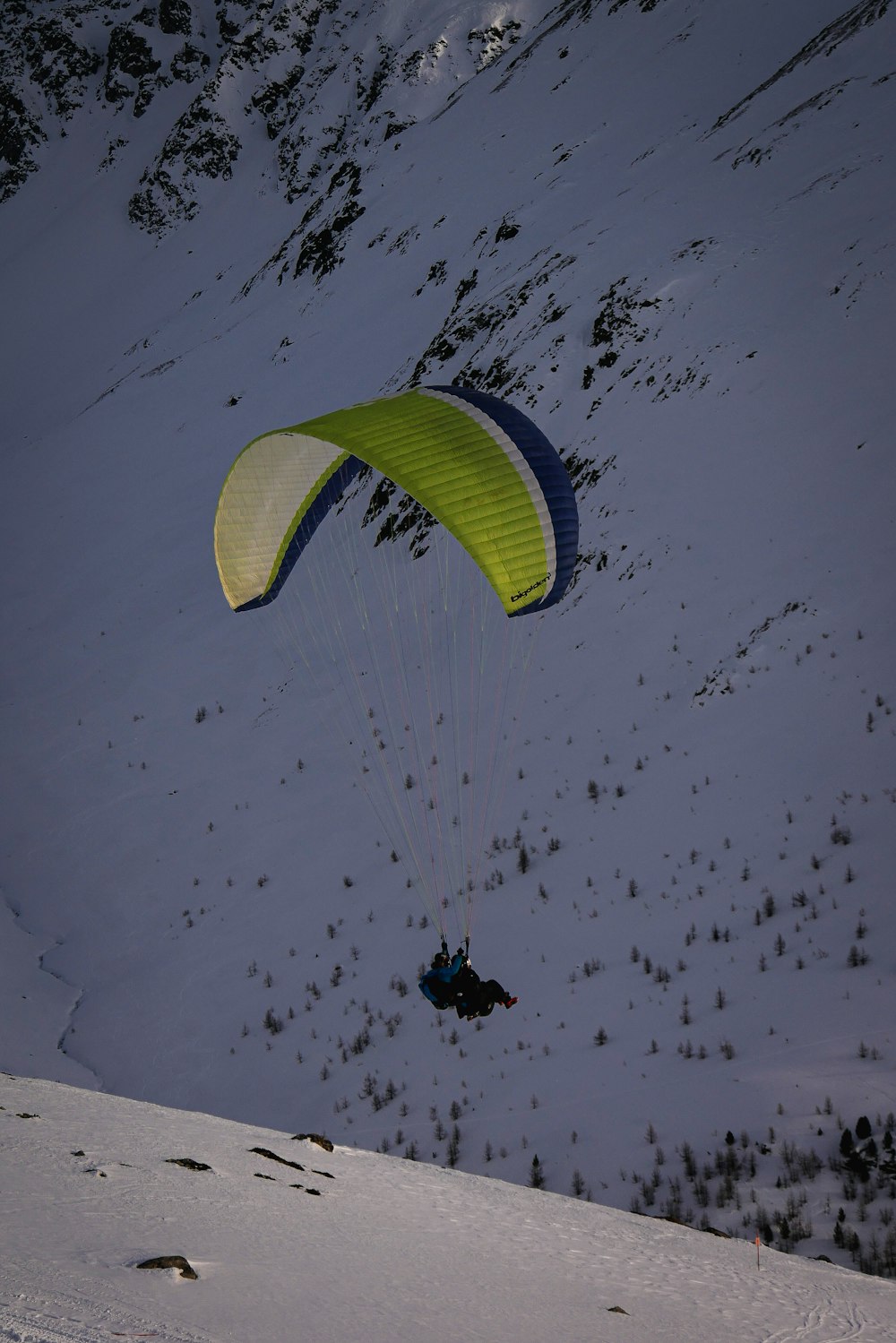 person in black jacket and black pants riding green parachute