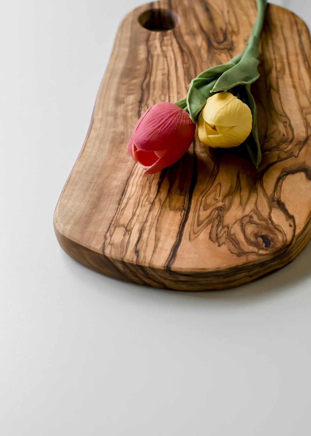 red and yellow tulips on brown wooden bowl