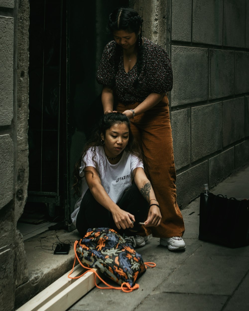 donna in vestito marrone che si siede accanto alla donna in vestito grigio e nero