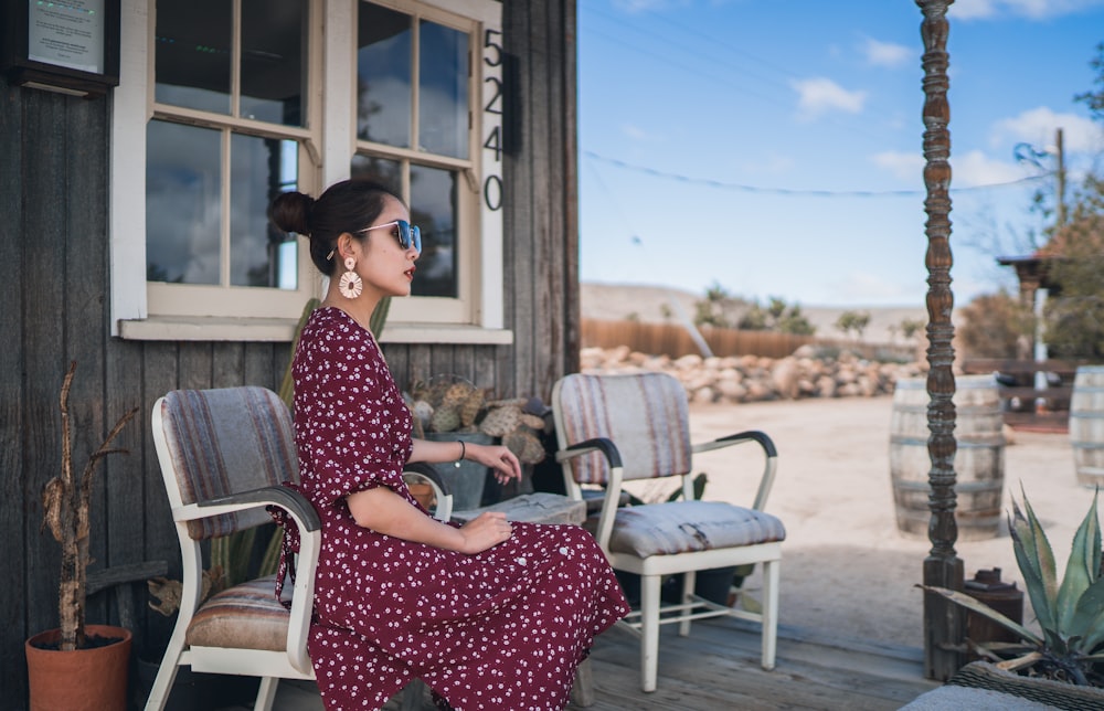 a woman sitting on a chair outside of a building