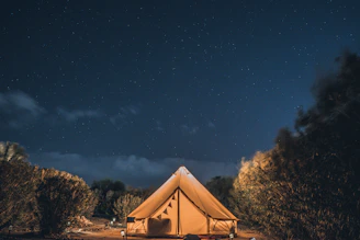 brown and white tent under blue sky during night time