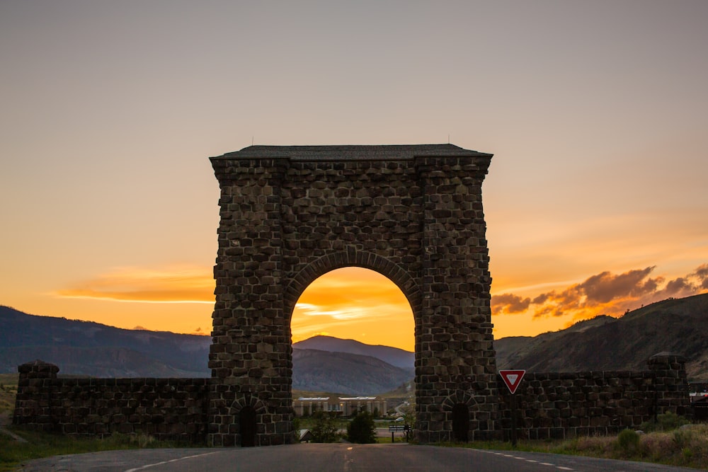 brown concrete arch under gray sky