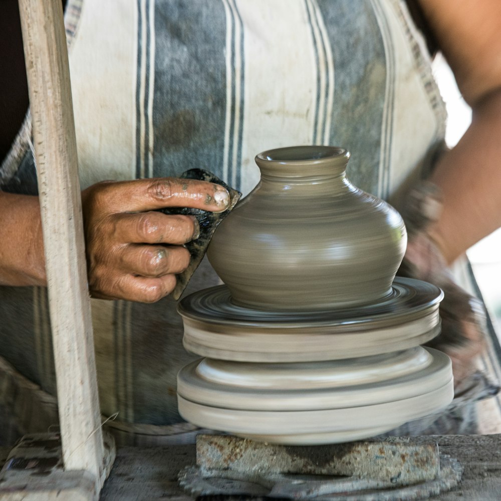 Person, die eine runde Schale aus weißer Keramik hält