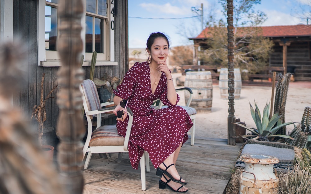 a woman is sitting on a chair outside