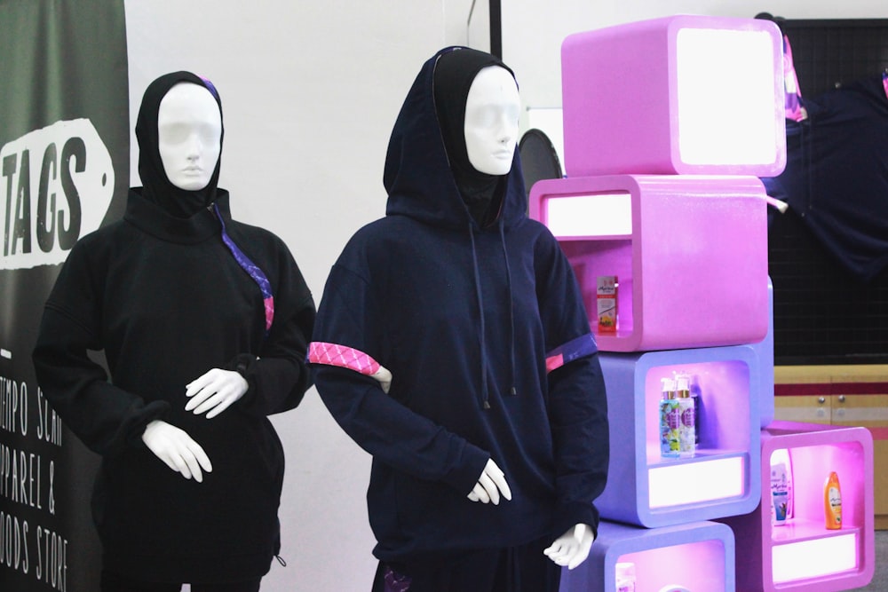 2 women in black hijab standing near pink plastic chair