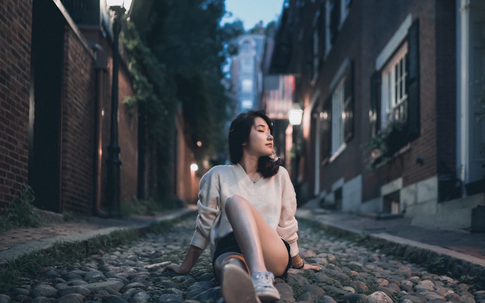 man in white t-shirt sitting on the ground