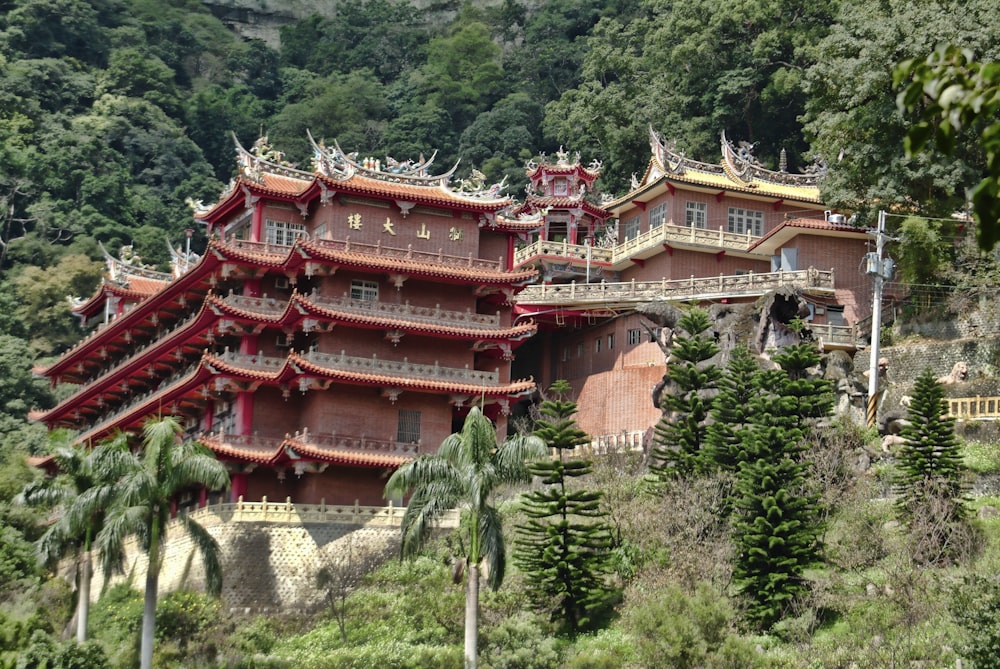red and brown temple surrounded by green trees during daytime