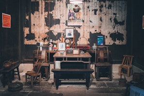 A rustic wooden table set with framed prints of French regional maps and cultural symbols.