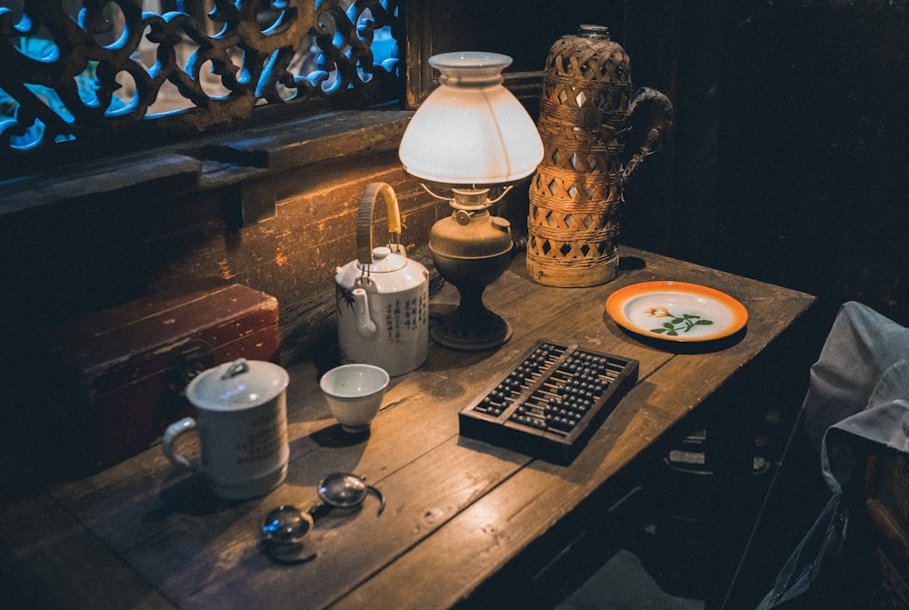 white ceramic mug on saucer beside black remote control