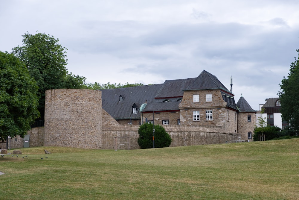 brown brick building near green grass field during daytime