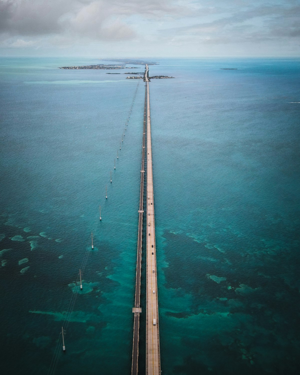 Wooden dock stretching into calm turquoise waters under clear blue sky in the Florida Keys