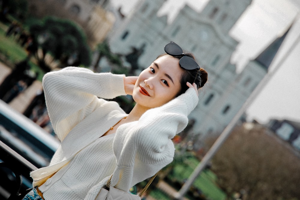 woman in white sweater wearing black sunglasses