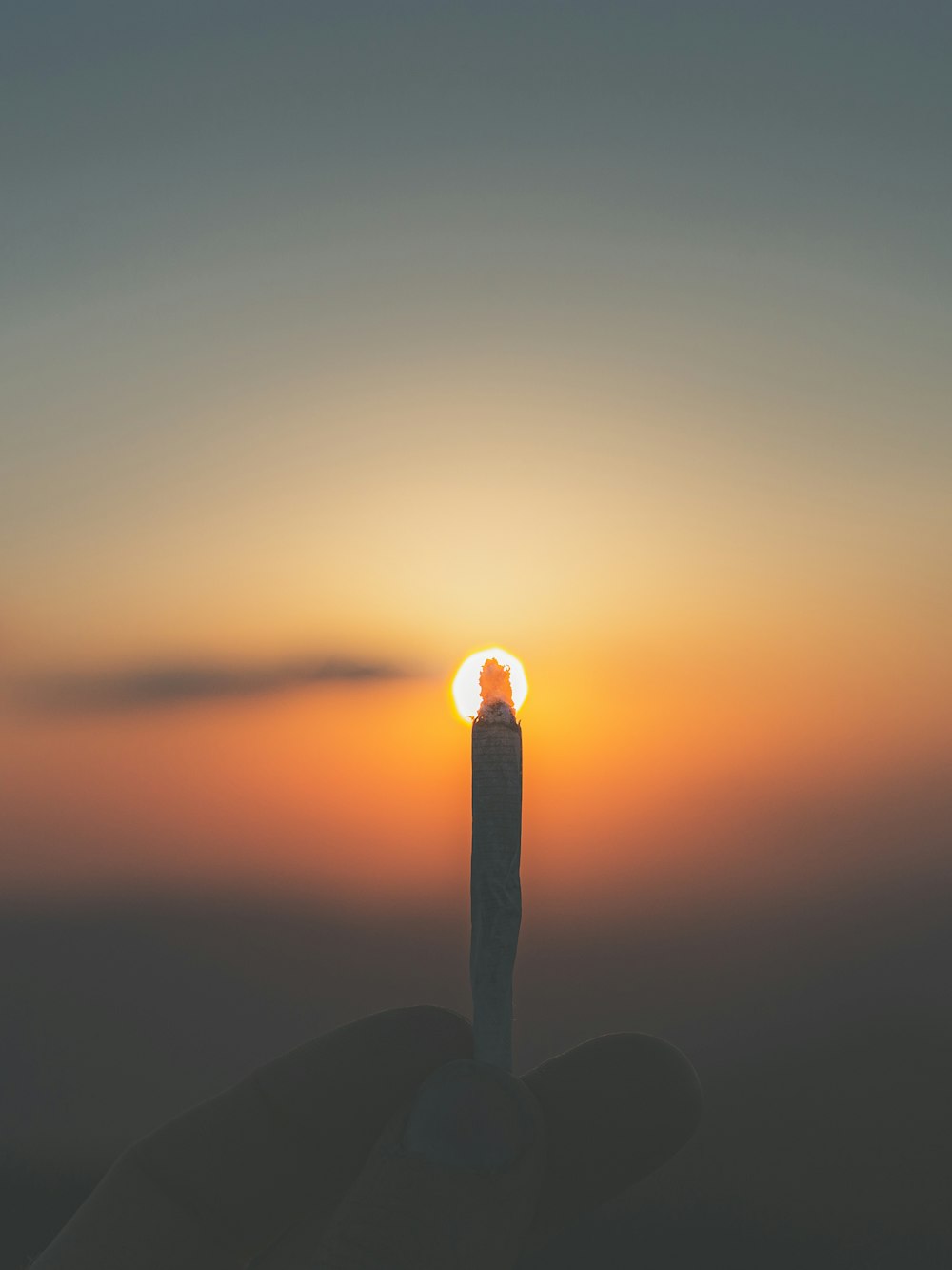 person holding lighted cigarette stick